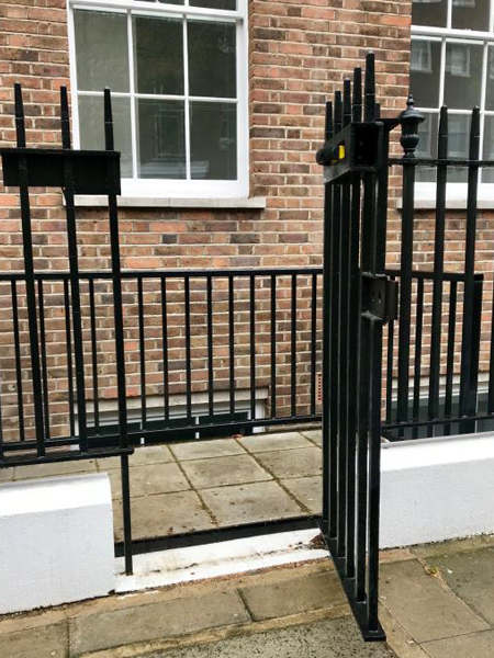 Black gate leading to lightwell lift entrance