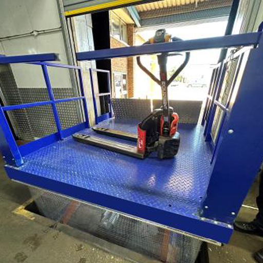 A blue platform lift in a warehouse, designed for efficient loading and unloading operations